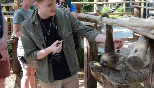 Young man feeding a sloth in the animal encounters at Wild Florida
