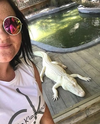 Woman takes a selfie with an Albino Alligator at Wild Florida