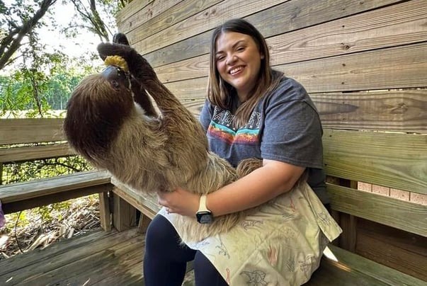 Woman holding a toe-toed sloth.